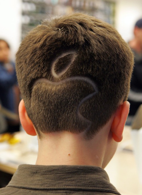 A boy with Apple Computer logo haircut, attends the opening of the Apple Store on Fifth Avenue, Friday, May 19, 2006 in New York. Apple's newest store, on the same shopping strip as Prada, Tiffany & Co. and Saks Fifth Avenue, marks five years of a distinctive retail style that both reinforces the company's brand cachet and pays off handsomely. (AP Photo/Dima Gavrysh) ORG XMIT: NYDG108