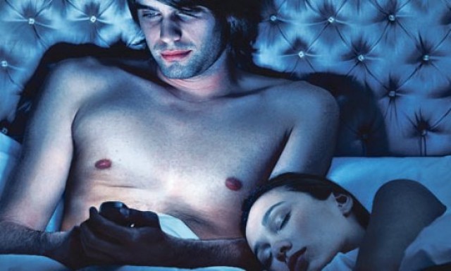 man-using-iphone-in-bed