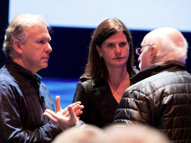 Katie Cotton with an Apple executive talking to a reporter