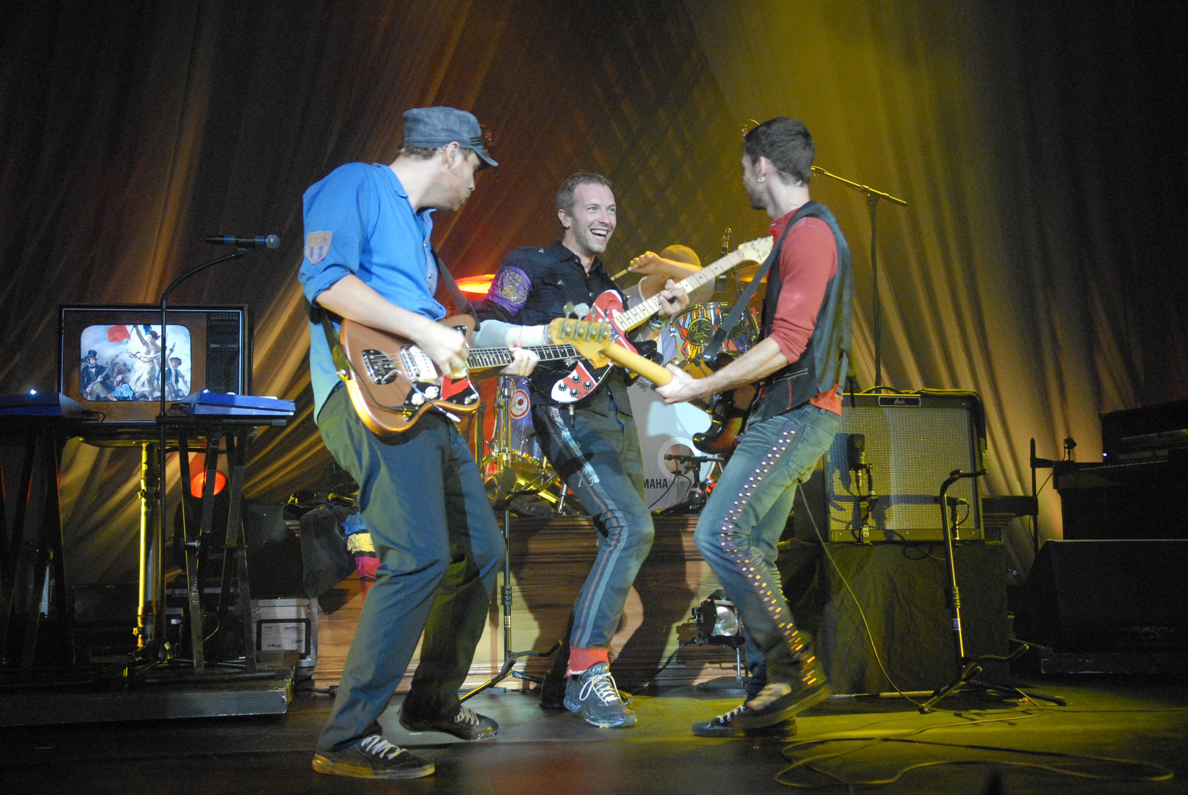Photo of British rock band Coldplay performing onstage.