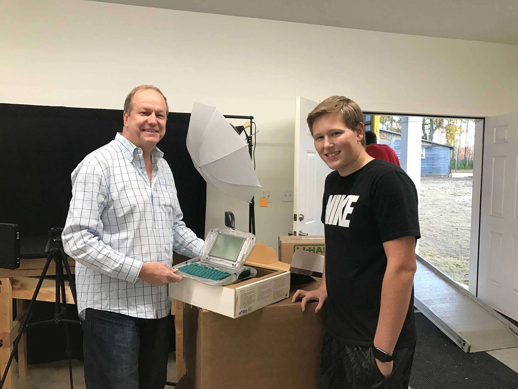 Vintage tech collectors Lonnie Mimms, left, and Alex Jason pose with an Apple e-Mate prototype, part of a collection Alex sold to Mimms.
