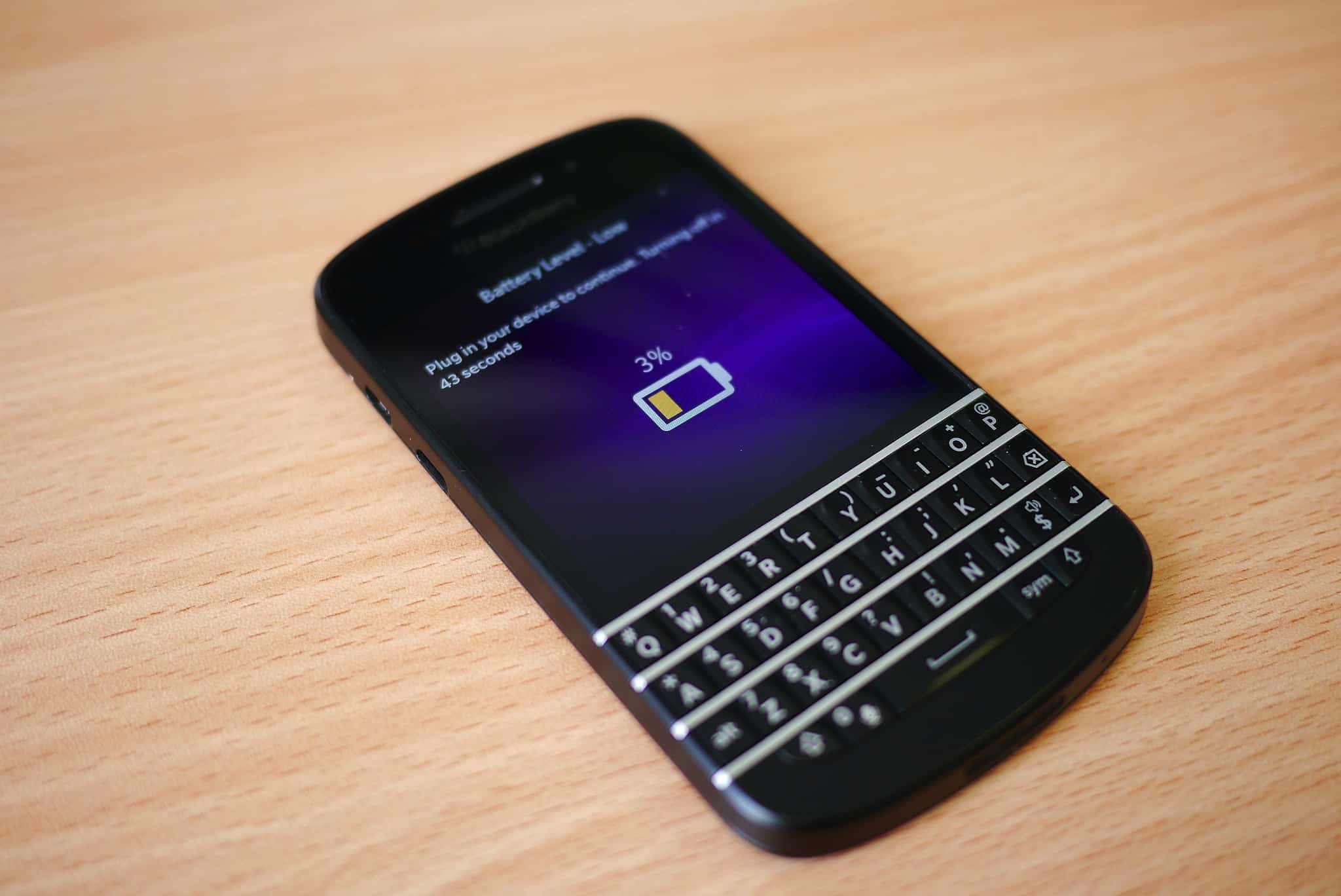 A BlackBerry device running BlackBerry OS that shows an empty battery icon on its screen.
