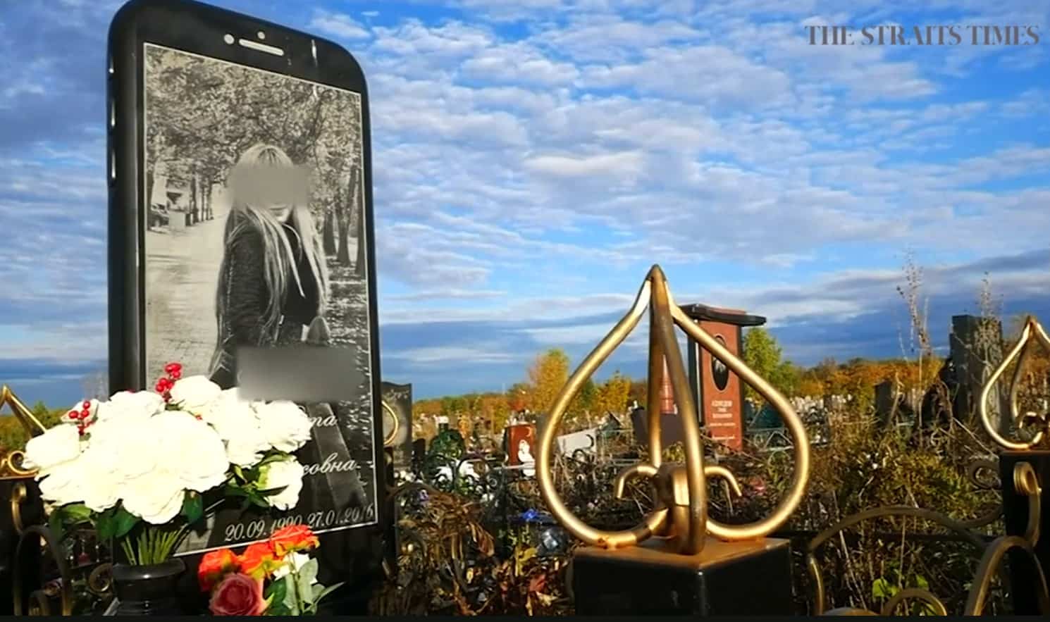 The iPhone gravestone stands tall in a Russian cemetery.