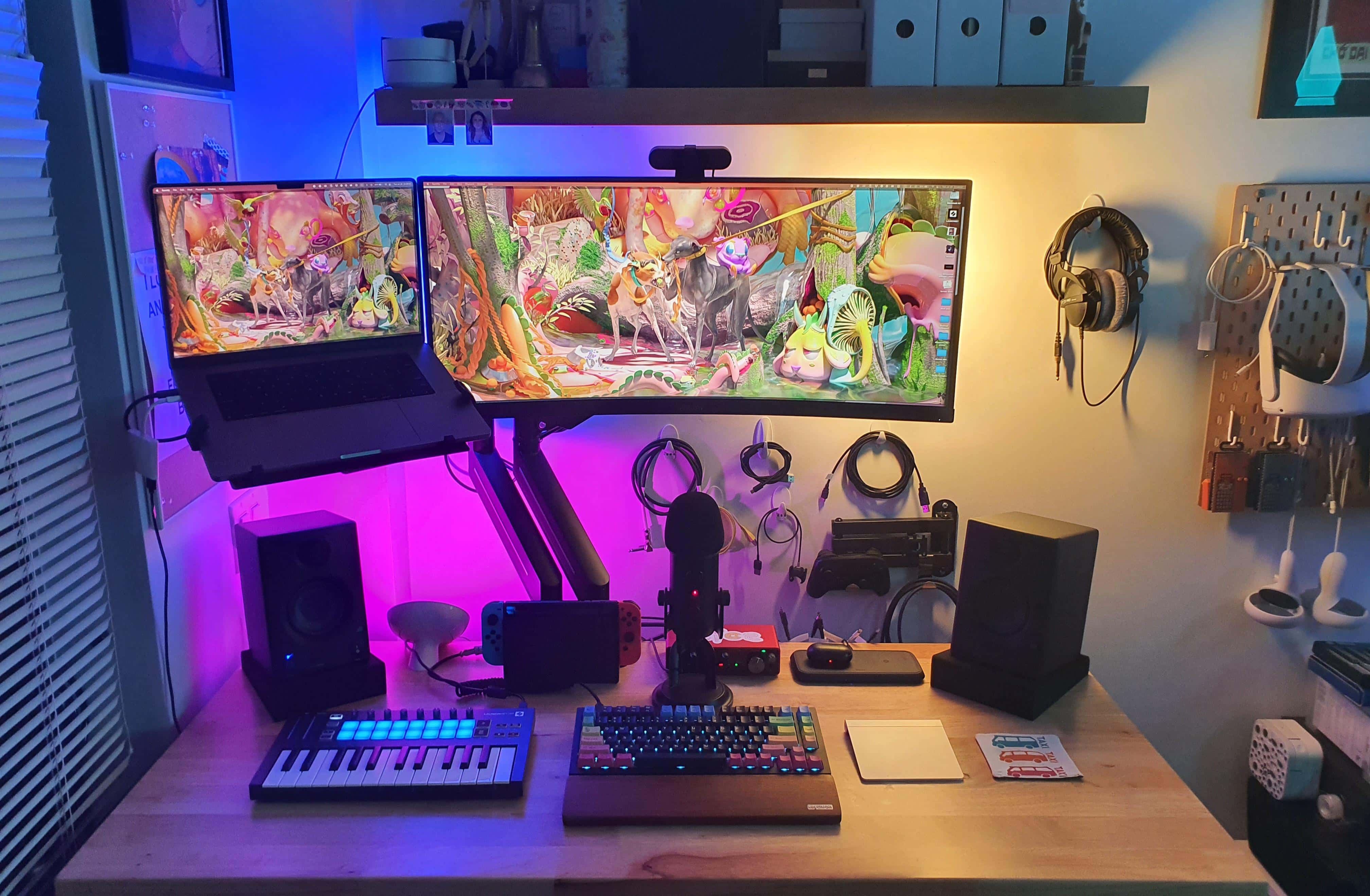 This excellent use of space is brought to you by a standing desk, a mounted ultra-wide display and MacBook Pro, and inventive wall storage.