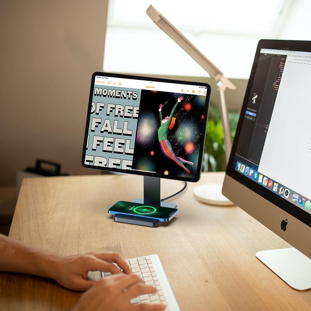 A Kuxiu magnetic iPad stand with an iPhone charging wireless on its base.