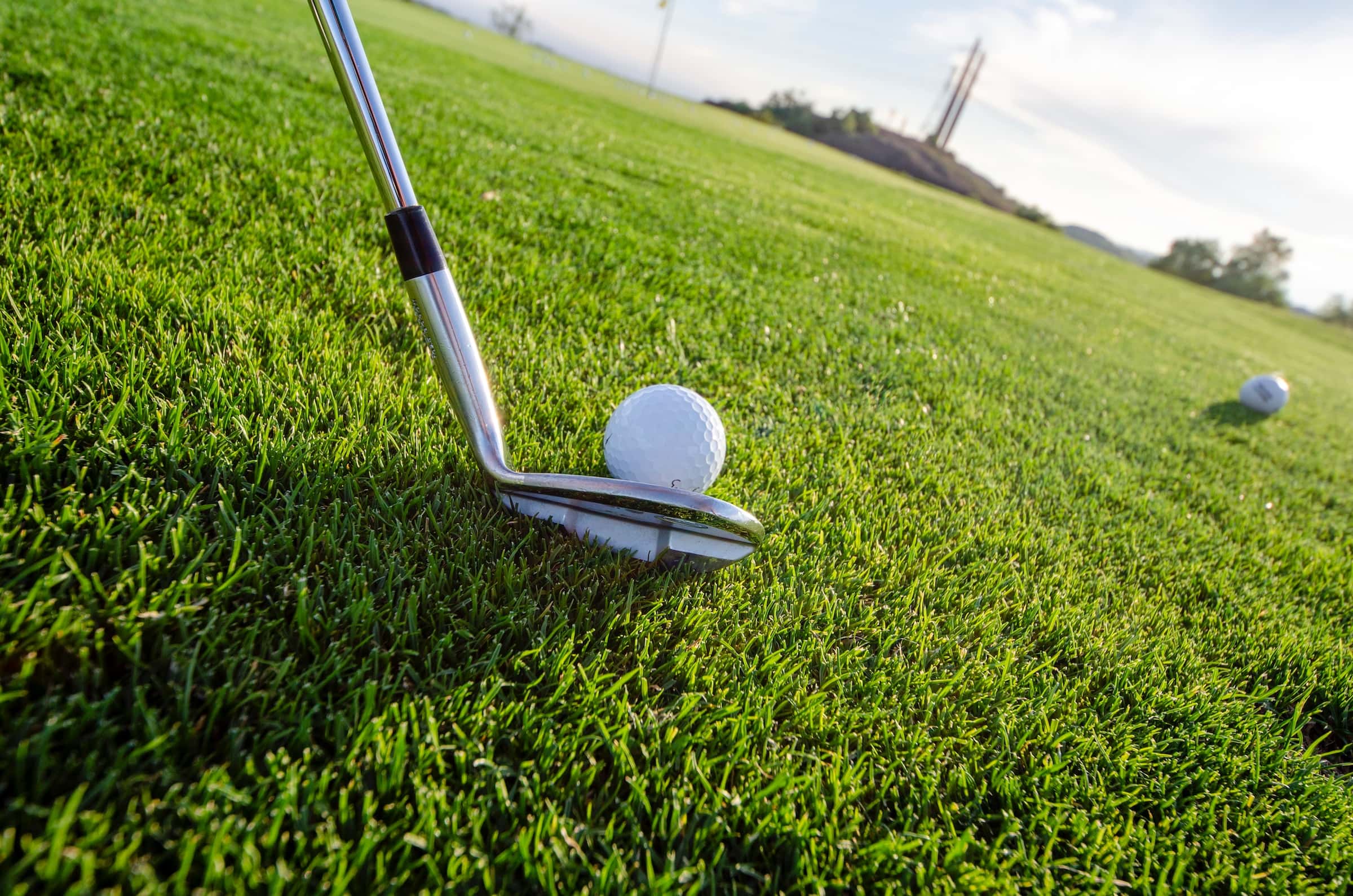 A golfer gets ready to hit a ball on a golf course.