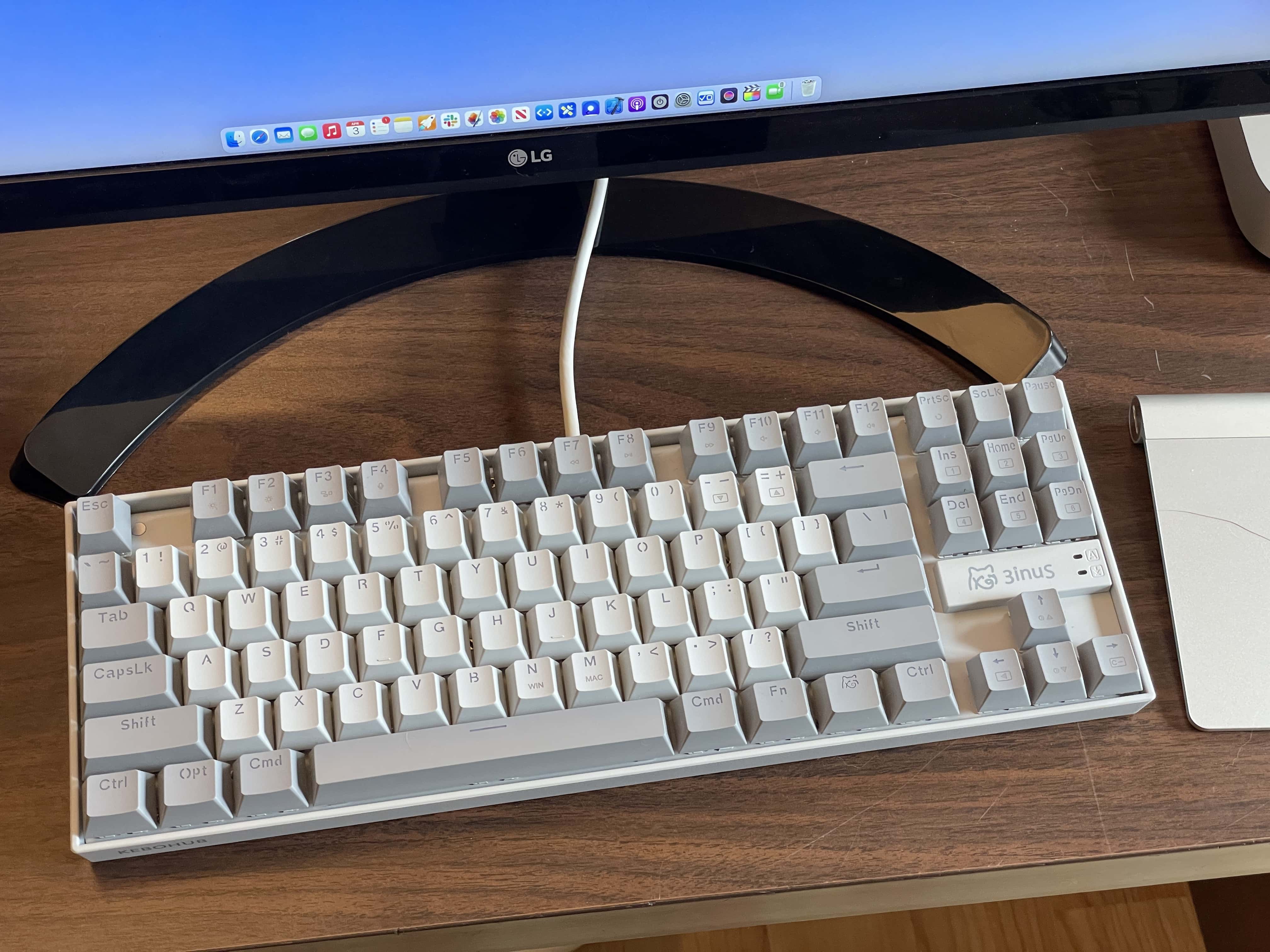 Kebohub EE01 sitting on a very scratched up desk with a Magic Trackpad