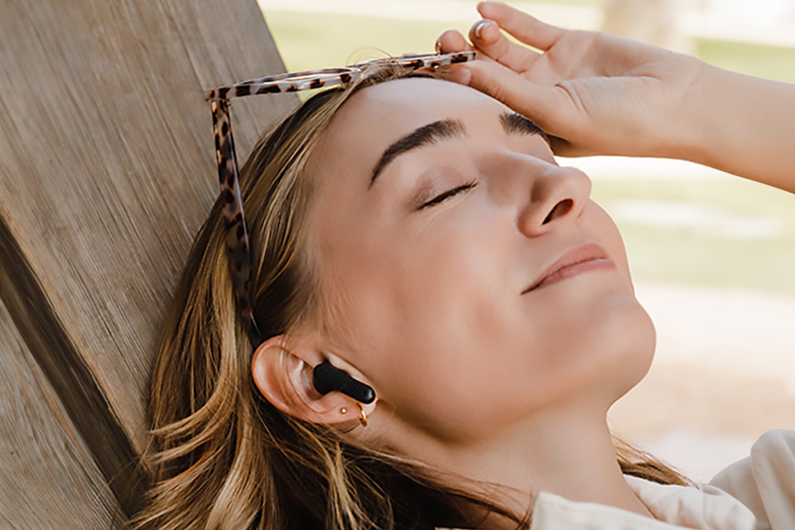 A woman wearing JBL Tune Flex noise-canceling earbuds.