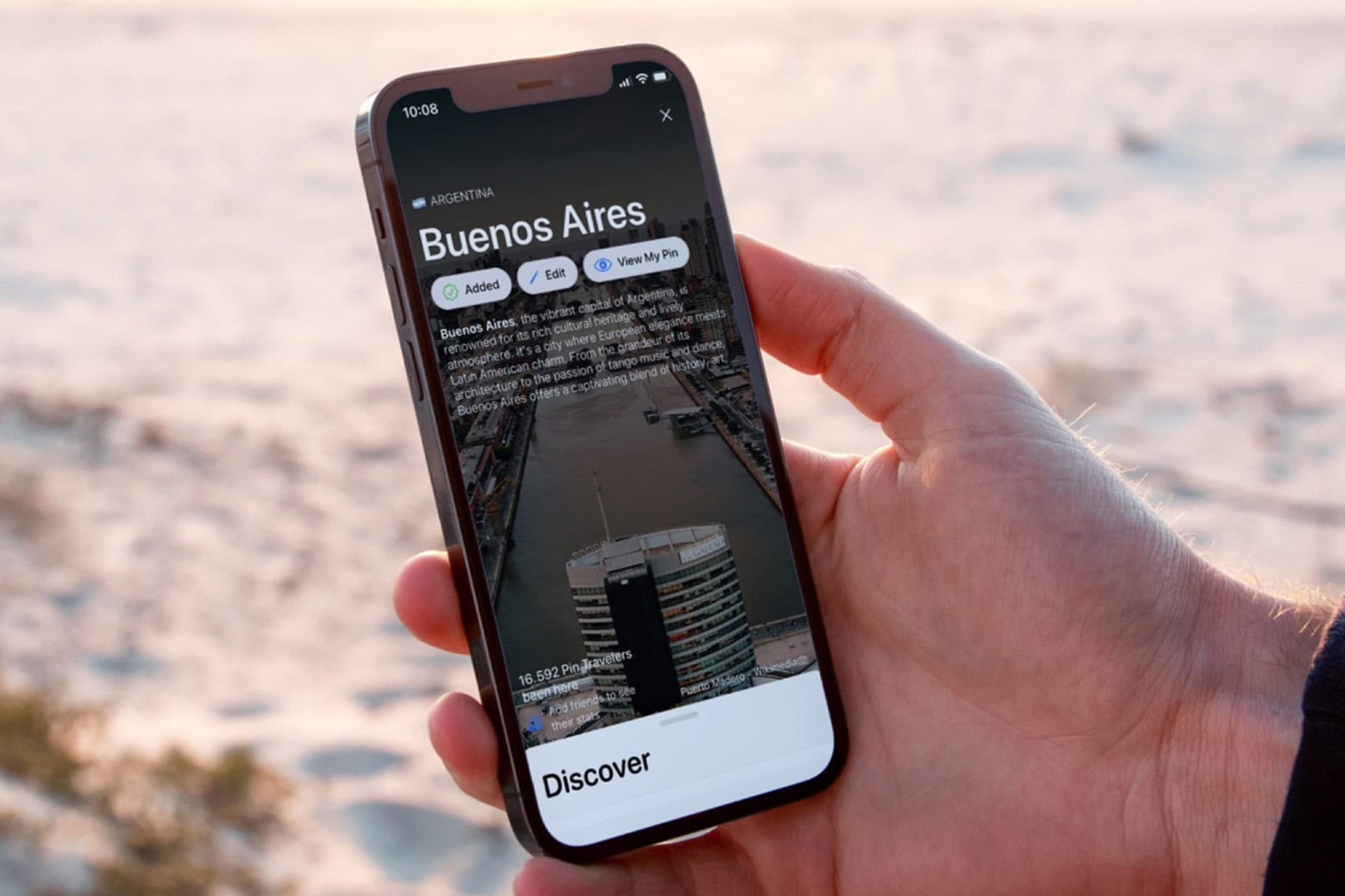 Man accessing the Pin Traveler travel-tracking app on his phone.