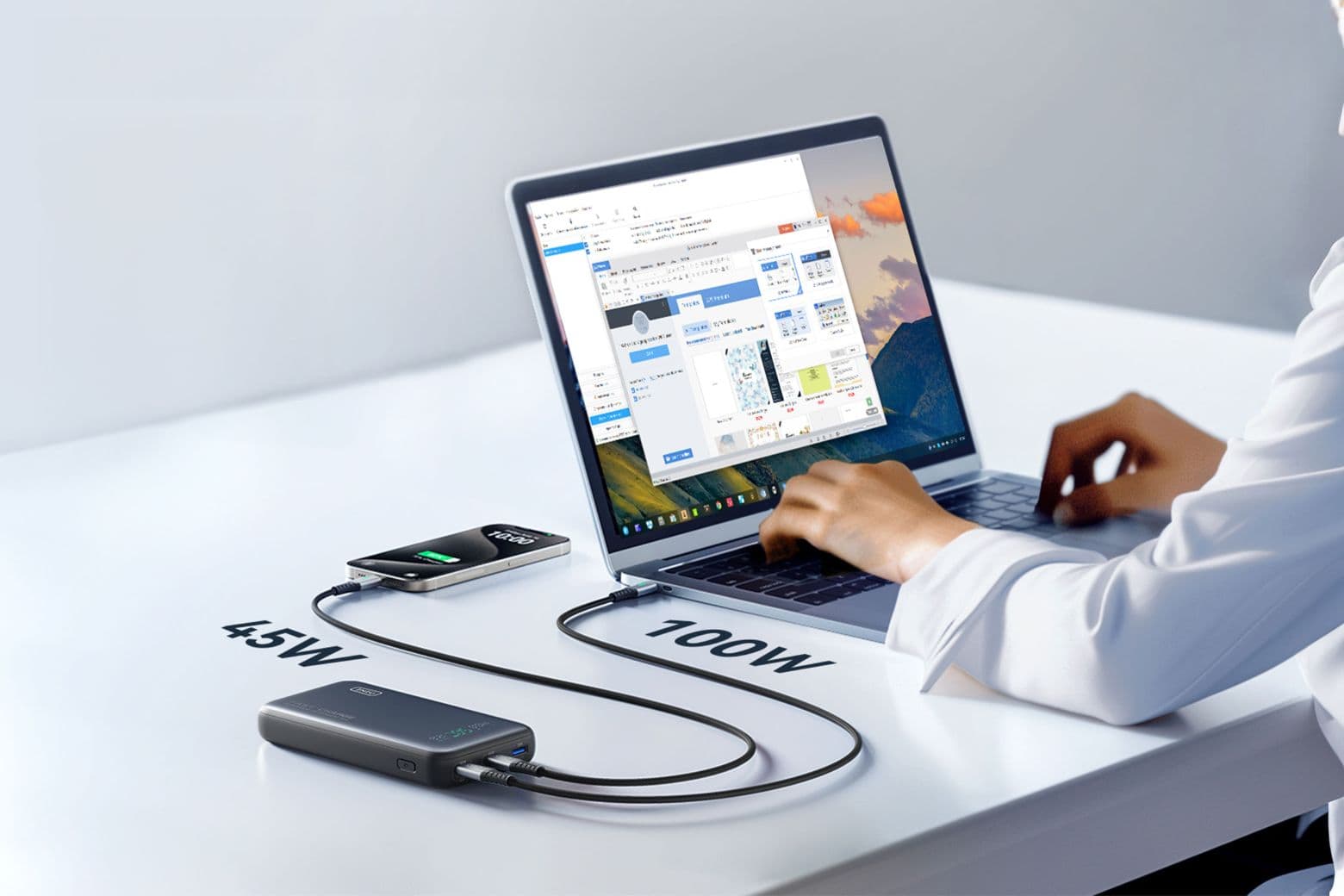Photo of a person charging a mobile phone and laptop with the Iniu Leopard 140W power bank.